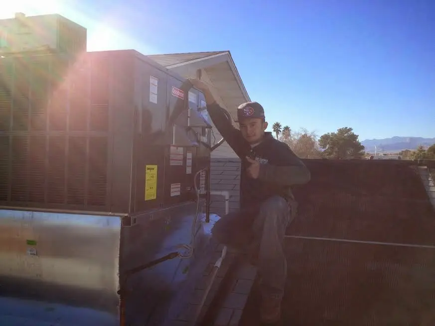 HVAC technician performing AC Tune-Up on a rooftop unit in Peachtree Corners
